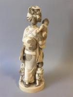 JAPON. Okimono en ivoire à décor d'une femme entourée de...