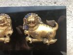 Deux petits LIONS en bronze doré monté sur panneau. Tibet,...