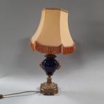 Une LAMPE en porcelaine bleu à monture en bronze. 
Style...