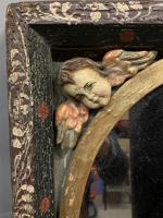 MIROIR en bois sculpté et peint à décor d'angelots, en...