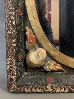 MIROIR en bois sculpté et peint à décor d'angelots, en...