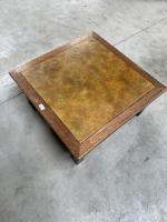 Une TABLE basse en bois, le plateau centré d'un carreau...