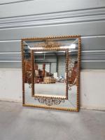 Années 1940
Miroir rectangulaire à encadrement en bois doré et cartouches...