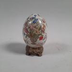 OEUF en porcelaine craquelée à décor floral polychrome, monté sur...