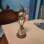 Sculpture en régule doré figurant une femme tenant un flambeau....
