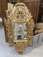 Un miroir à parecloses en bois doré style Louis XVI
Petit...