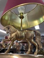 LAMPE en métal doré à décor d'un cheval, l'abat-jour rouge...