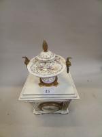 Une pendule en porcelaine polychrome et bronze doré, à décor...