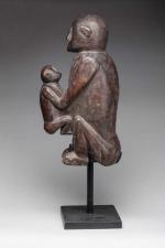 Statuette en bois représentant une mère singe assise tenant son...