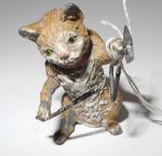 Sculpture en plomb polychromée figurant un chat jouant du triangle....