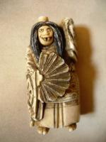 OKIMONO en ivoire sculpté figurant un personnage à l'éventail à...