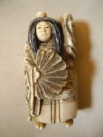 OKIMONO en ivoire sculpté figurant un personnage à l'éventail à...
